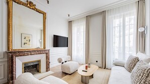 Ein Wohnzimmer mit Kamin, einer Couch, einem Couchtisch und einem Fernseher.
