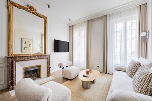 Ein Wohnzimmer mit Kamin, einer Couch, einem Couchtisch und einem Fernseher.