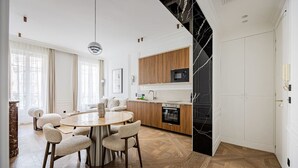 Eine moderne Küche mit Holzausstattung, einer schwarzen Marmor-Spritzschutzwand und einem eingebauten Backofen.