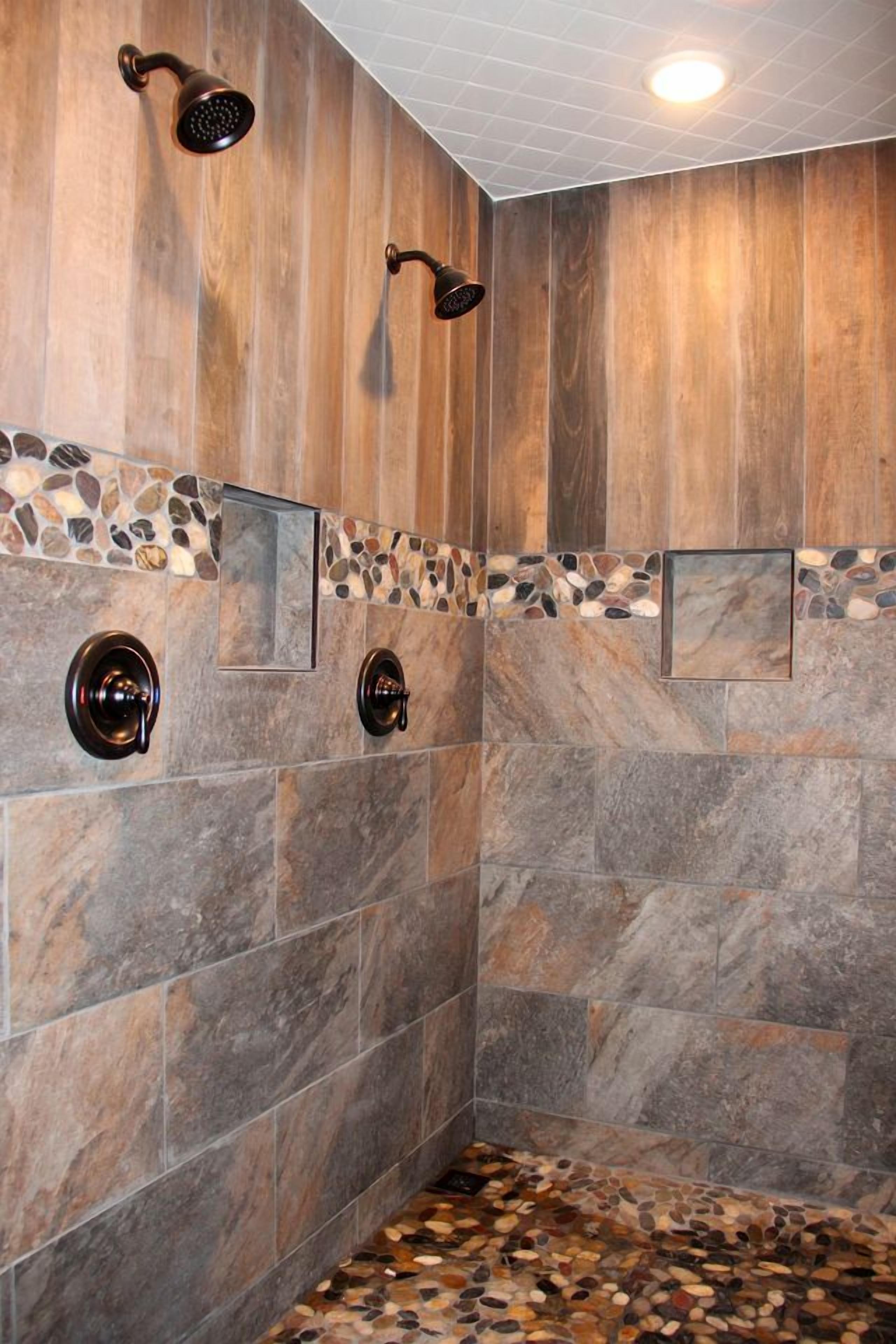 A shower with wooden paneling and stone tiles, including a pebble-patterned floor.