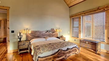 Un dormitorio con cama de madera, dos mesitas de noche con lámparas, cabecero de madera y una ventana con persianas.