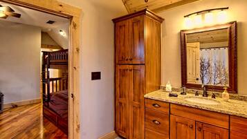 A bathroom with wooden cabinets, a sink, and a mirror.
