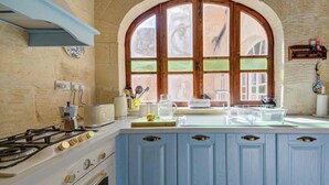 Una cocina con estufa a gas, un lavamanos y una ventana con vistas.