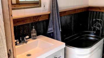 A bathroom with a white sink, a mirror, a towel rack, and a bathtub.