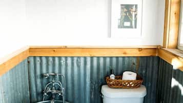 Un baño con bañera, inodoro y una pequeña ventana.
