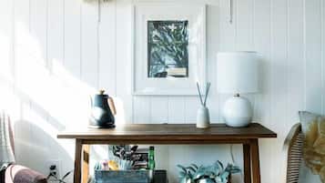 A wooden table with a lamp, books, and a framed picture on a wall.