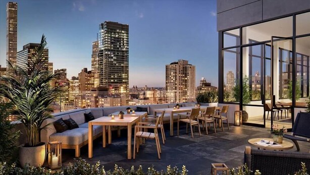Une terrasse sur le toit avec des sièges en plein air, une vue imprenable sur les toits de la ville et une architecture moderne.