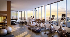 A modern gym with various exercise equipment, large windows, and a city view. - Walkable 1BR nr Park Ave & Grand Central (New York)