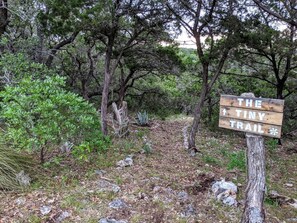 A wooden signpost with the text 'THE TINY TRAIL' and an arrow pointing upwards. - Tiny House with Amazing Views and Private Hiking Trails in Hill Country, Texas (Pipe Creek)