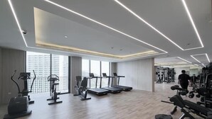 A modern gym with treadmills, elliptical machines, and weight equipment. - Vogue | Luma Park Views JVC Near Circle Mall (Dubai)