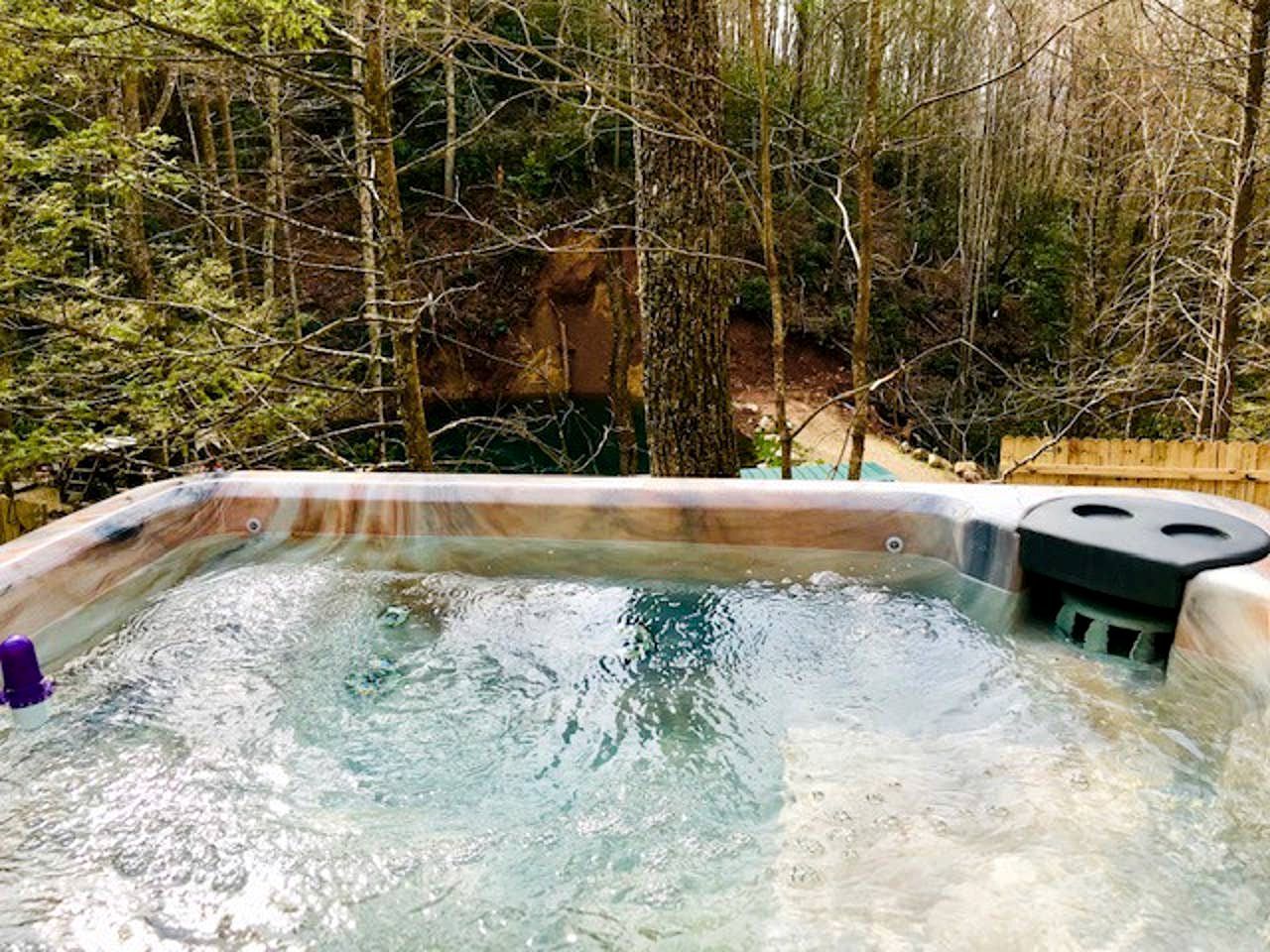 A hot tub surrounded by trees.