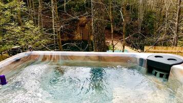 A hot tub surrounded by trees.