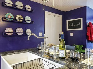 A kitchen with a sink, wine bottle, and decorative plates on shelves. - Elegant Farm Cottage Rental for a Countryside Getaway near Lancaster, Pennsylvania (Columbia)