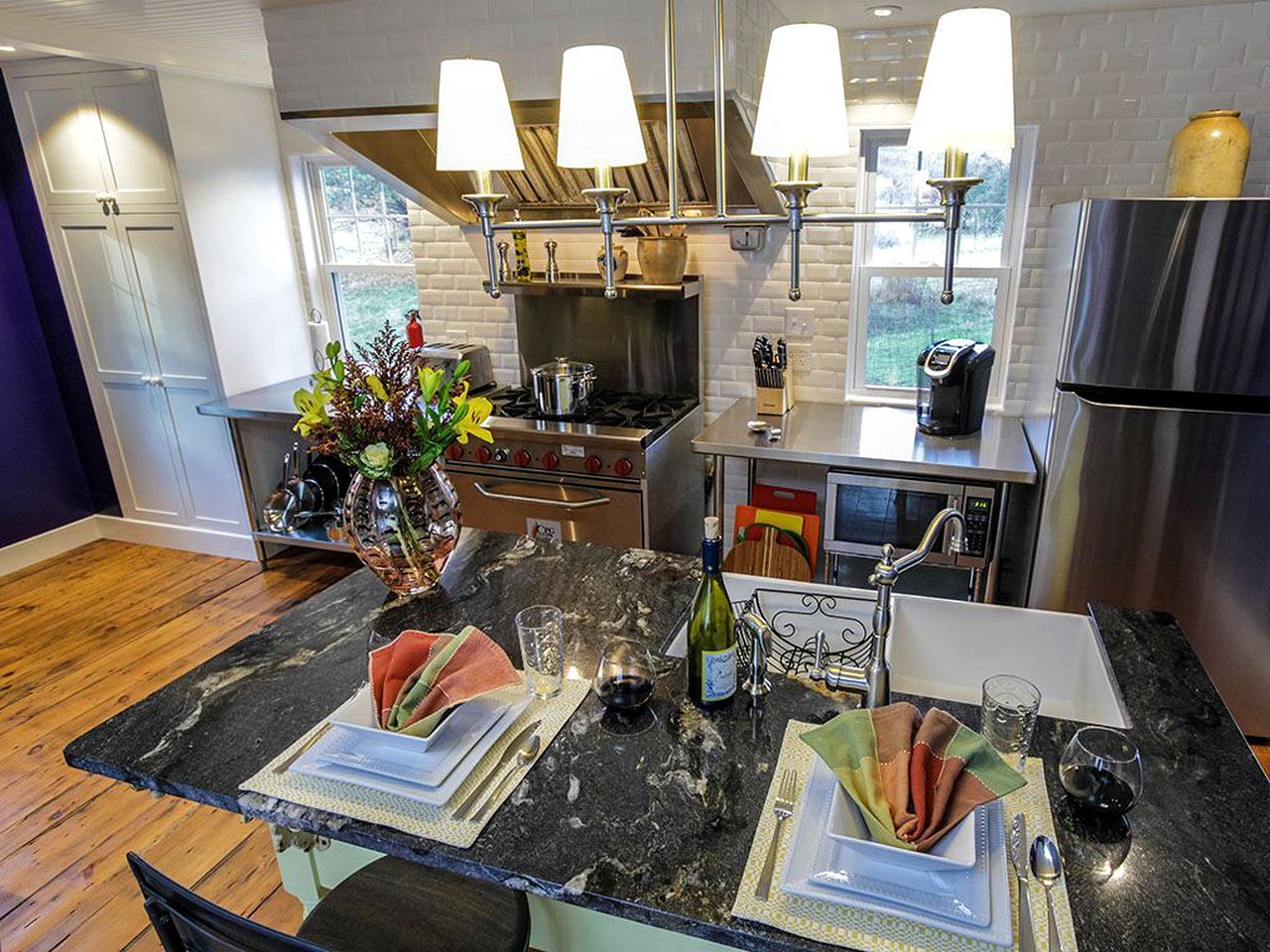A modern kitchen with a central island, stainless steel appliances, and pendant lighting.