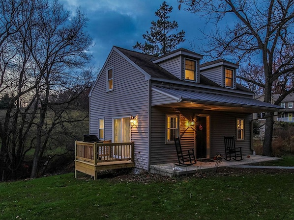 A two-story house with a porch, a deck, and a small garden area. - Elegant Farm Cottage Rental for a Countryside Getaway near Lancaster, Pennsylvania (Columbia)