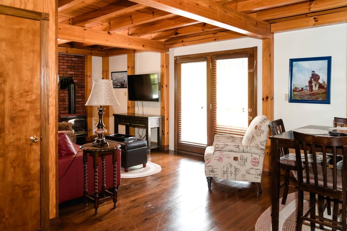 Un interior de madera con televisor, chimenea y zona de estar.