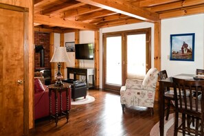 Un interior de madera con televisor, chimenea y zona de estar.