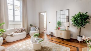 A living room with a sofa, a coffee table, a cabinet, and a large plant. - The Gallo Promenade in Lucca (Lucca)