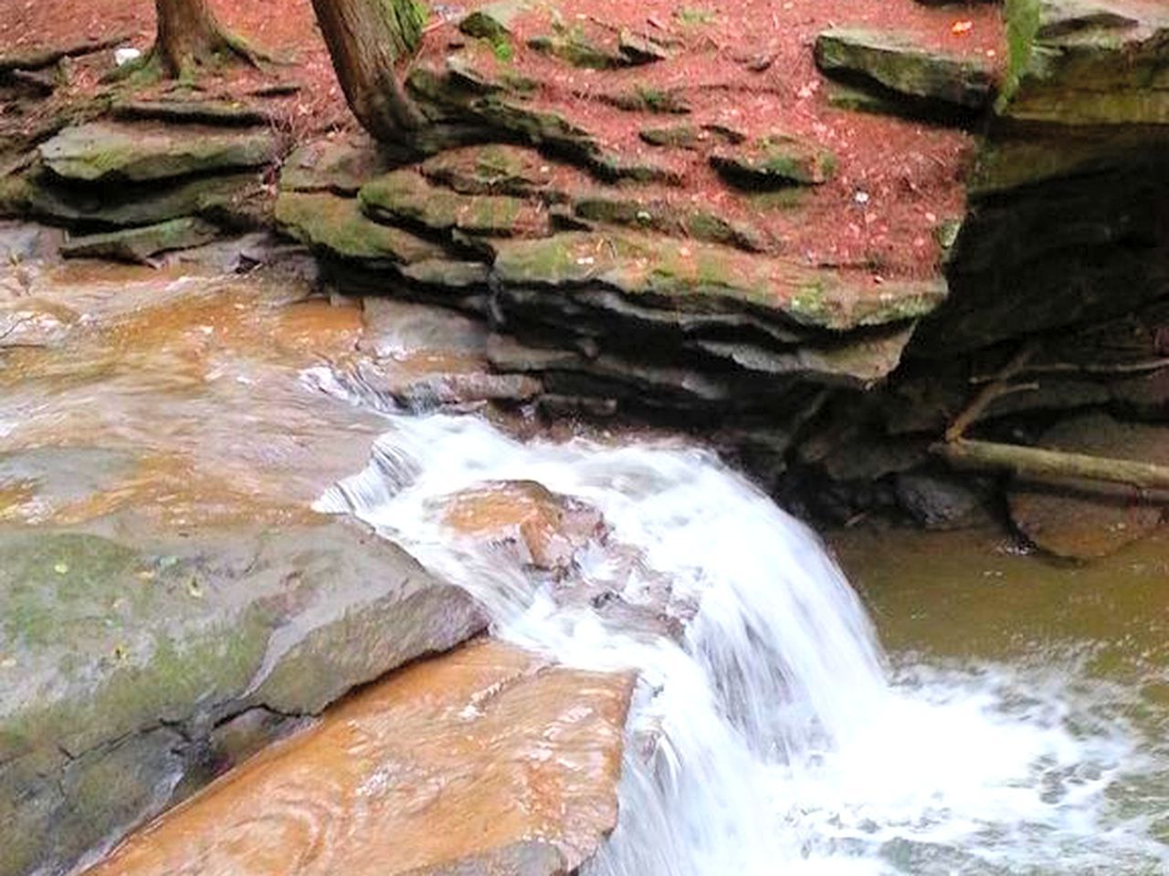 A natural water stream flowing over rocks.