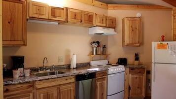 A kitchen with wooden cabinets, a stove, a dishwasher, and a refrigerator.