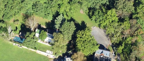 An aerial view of a residential area with houses surrounded by dense greenery.