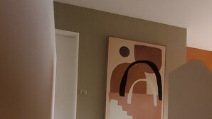 A staircase leading to a room with a large abstract painting on the wall.