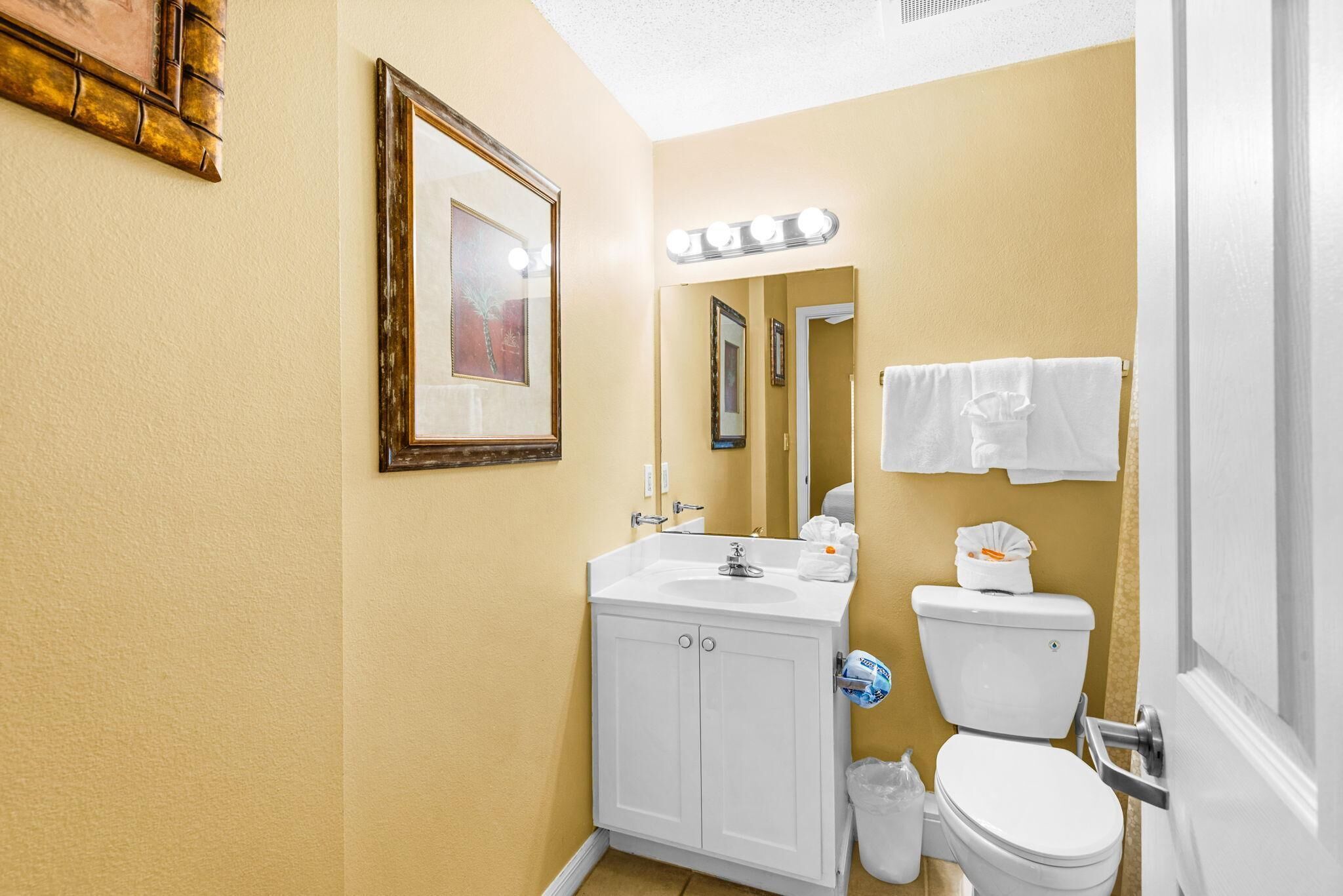 A bathroom with a sink, mirror, and toilet.
