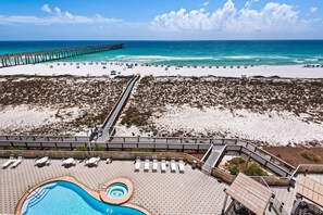 A beach resort with a swimming pool, sun loungers, and a pier extending into the ocean. - Summerwind Center 504 (Navarre)