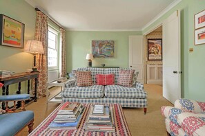 A cozy living room with a checkered sofa, a coffee table with books, a lamp, and a painting on the wall. - Gorgeous 3 bedroom flat - Pimlico (Greater London)