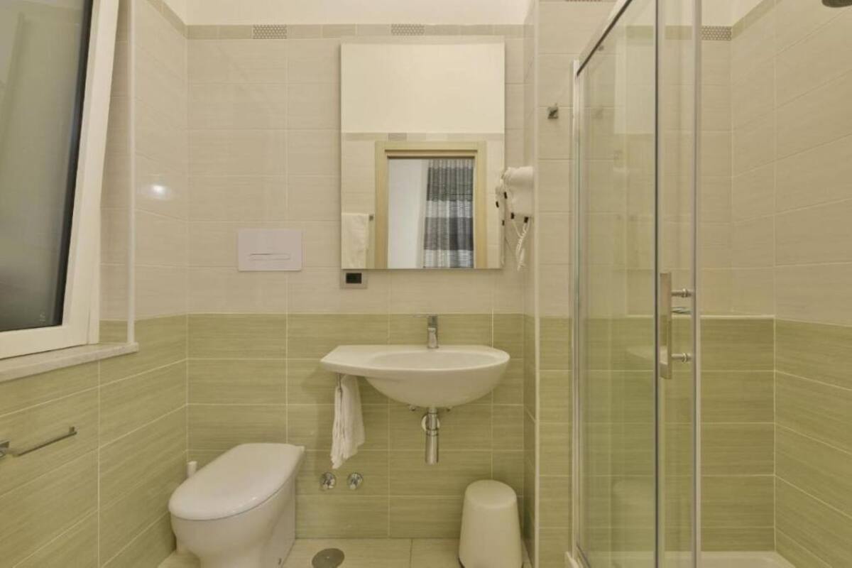 Une salle de bain équipée de toilettes, d’un lavabo et d’une douche à parois en verre.