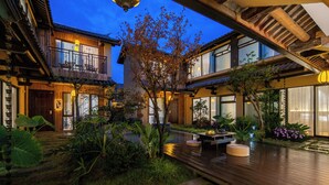 A traditional Japanese-style building with a wooden deck, a small garden, and a lantern.