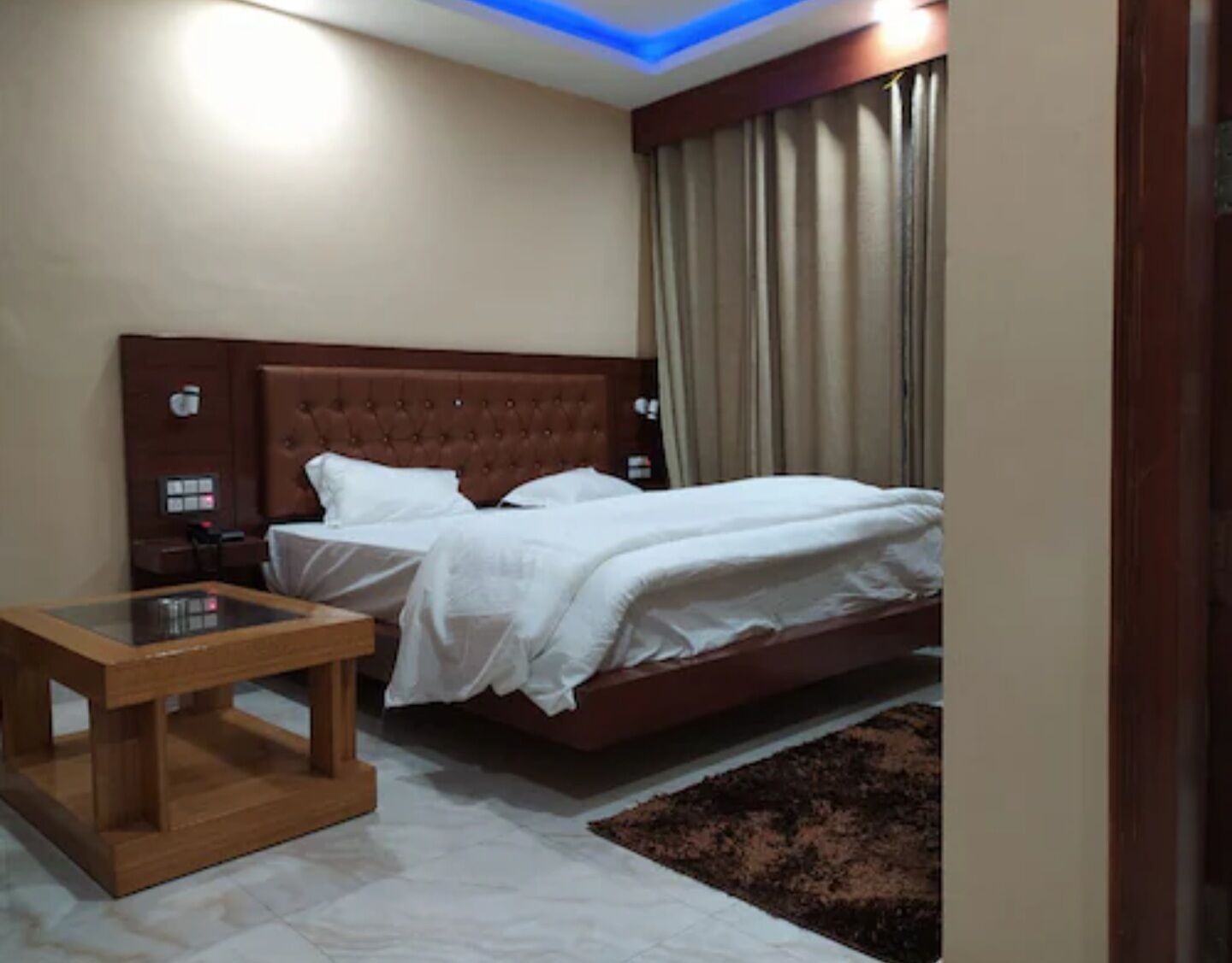 A bedroom with a bed, bedside table, and a nightstand.