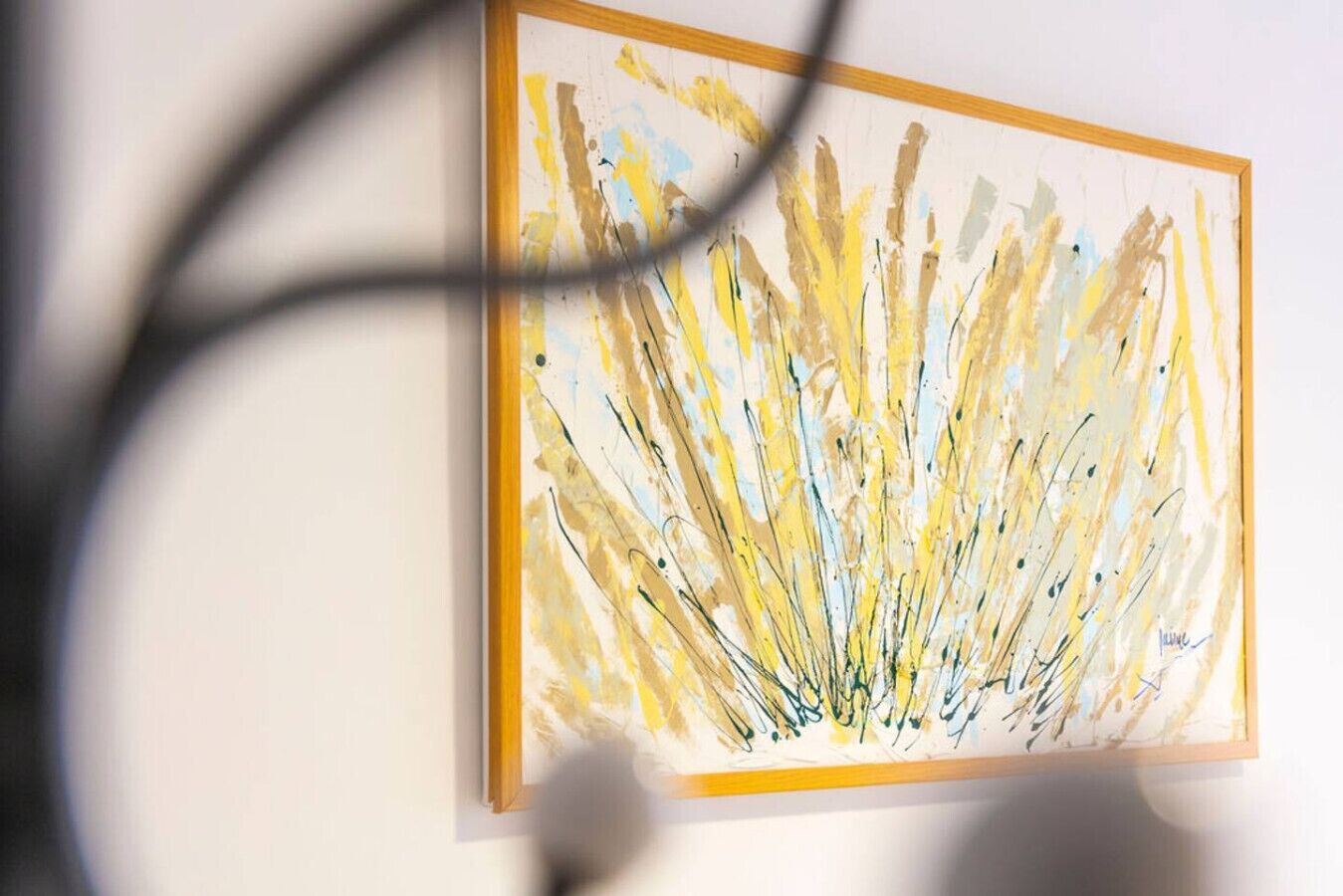 A framed abstract painting on a wall.