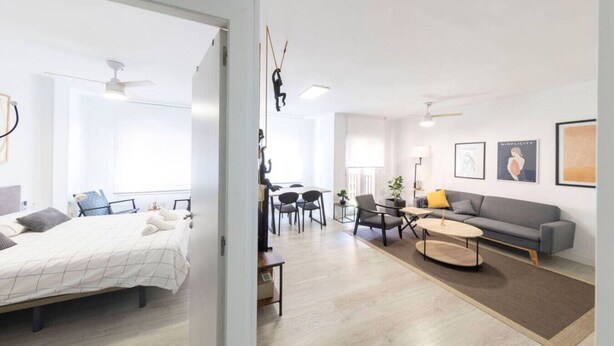 Un appartement moderne comprenant un lit, un canapé, un coin repas et une cuisine.
