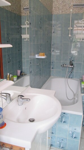 Une salle de bain avec deux lavabos, une baignoire et une douche.