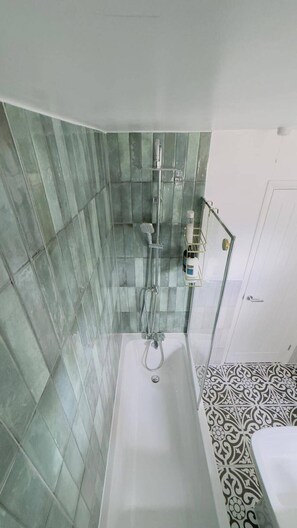 Un baño con ducha, inodoro y lavamanos.