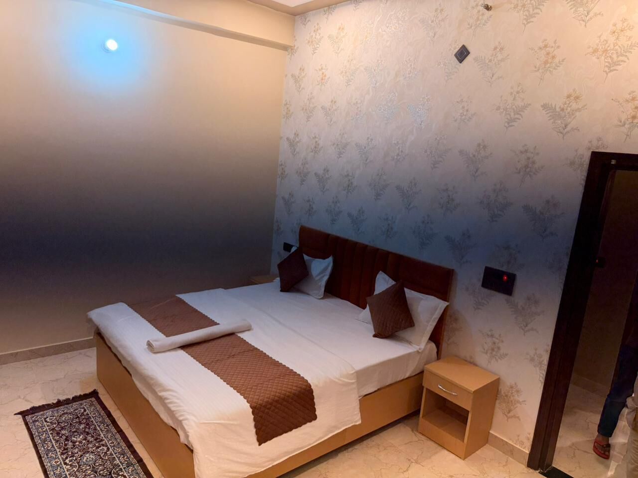 A bedroom with a bed, bedside table, and a nightstand.