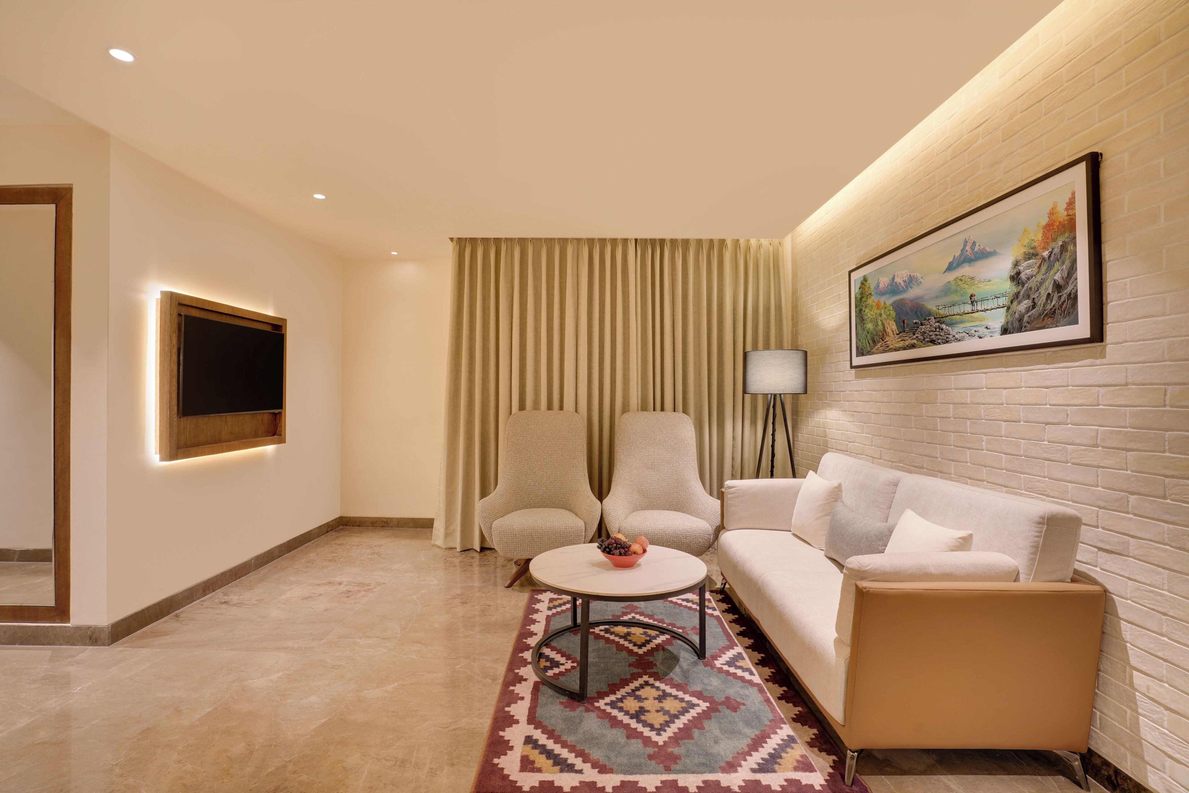 A modern living room with a sofa, two armchairs, a coffee table, a TV, and a painting on the wall.