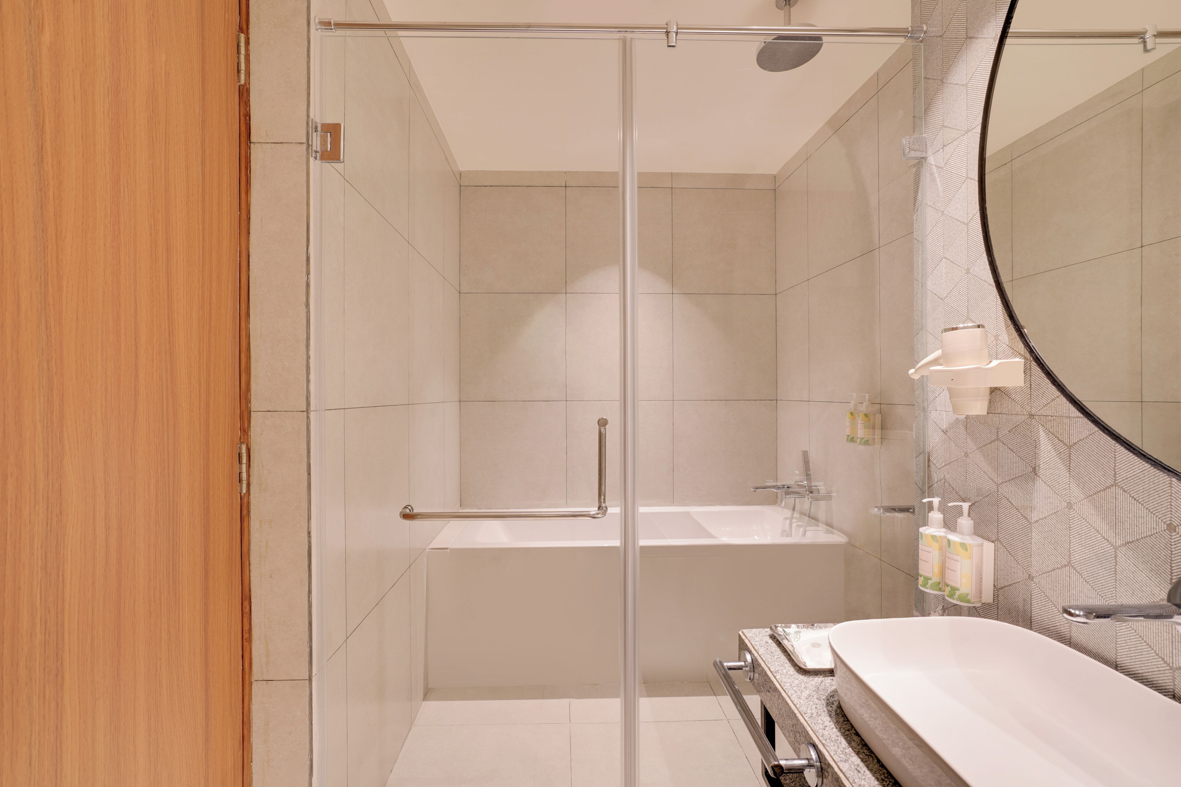 Ein modernes Badezimmer mit Duschkabine aus Glas, freistehender Badewanne und Waschtisch mit Spiegel.
