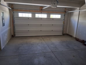 Un garage con porta chiusa, pavimento in cemento e travi in legno.