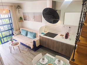 A compact living space with a kitchenette, a dining area, and a bed with blue pillows. - CASA SOL beautiful bungalow located in Campo International Maspalomas G. Canary Islands (CN)