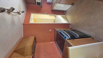 A compact kitchen with a stove, oven, microwave, and a sink.