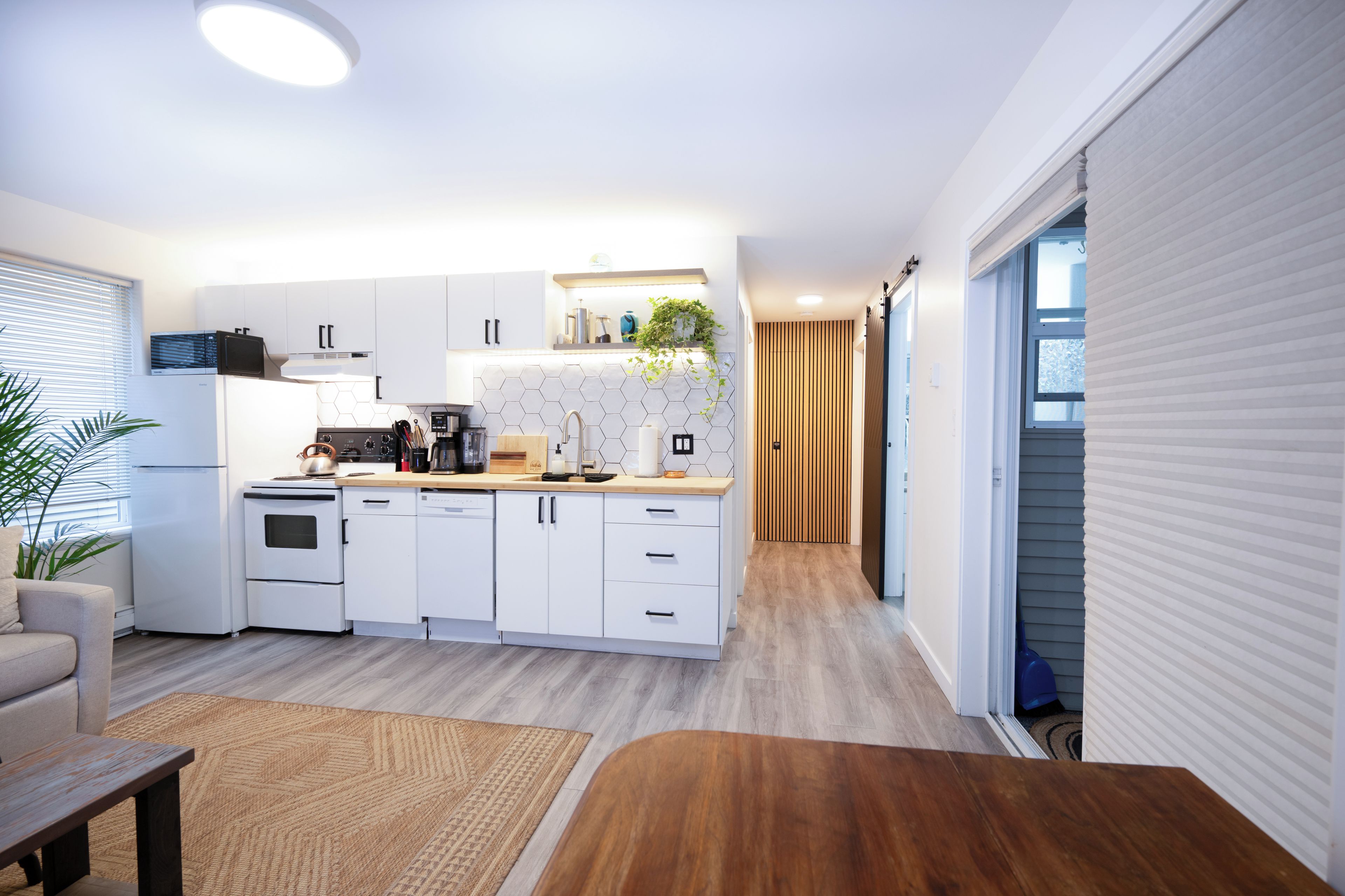 Eine moderne Küche mit weißen Schränken, einem Backofen und einer Kaffeemaschine.