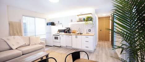 A modern kitchen with white cabinets, a wooden countertop, and a built-in oven.
