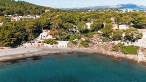 Un pueblo costero con casas, una playa y un mar azul cristalino.