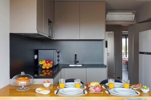 Eine moderne Küche mit Essbereich, einer Obstschale und Frühstücksgebäck auf dem Tisch.