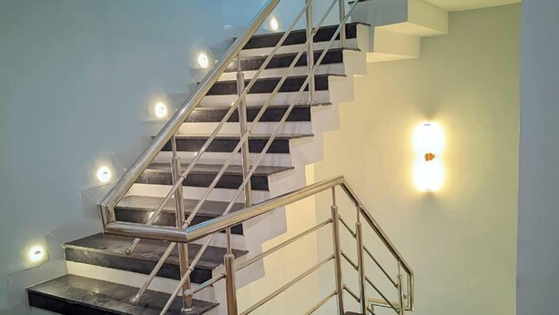 A modern staircase with metal railings and illuminated steps. - AVR Hotel (Indore)