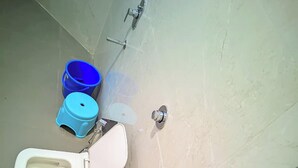 A bathroom with a toilet, a sink, and a shower. - AVR Hotel (Indore)