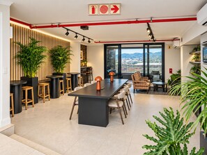 A modern kitchen with a central island, bar seating, and large windows offering a view of the city. - Maritime Place (Cape Town)