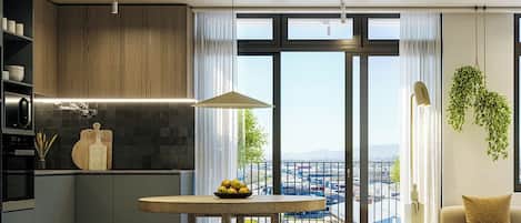 A modern kitchen with a dining area, large windows, and a view of the city.